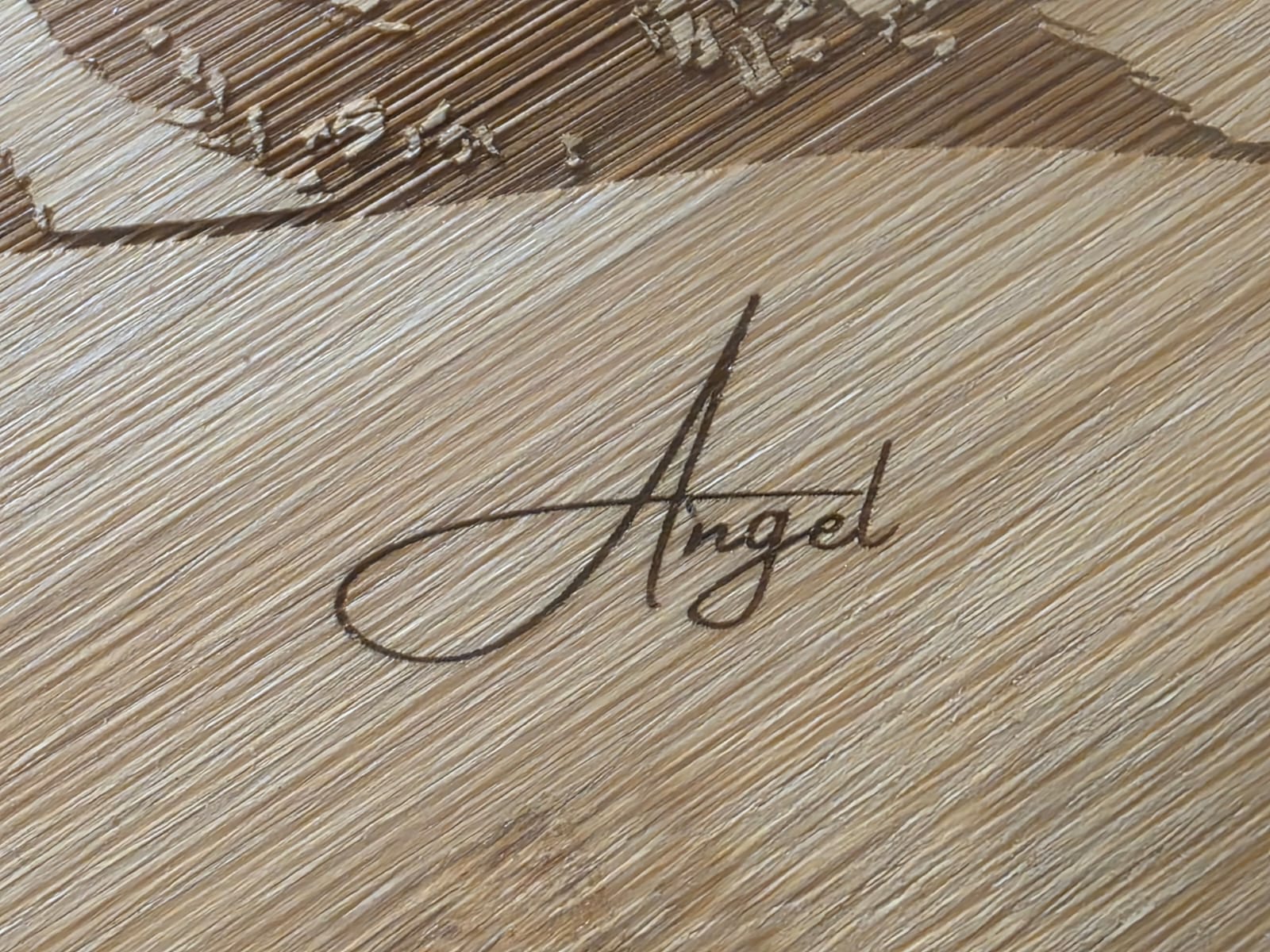 Detail einer Schriftgravur auf einem Holzbrettchen